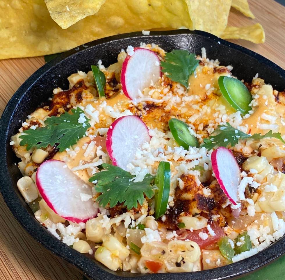Cutline for image: Street corn dip with chips is being served during tacos and tequila month in ...