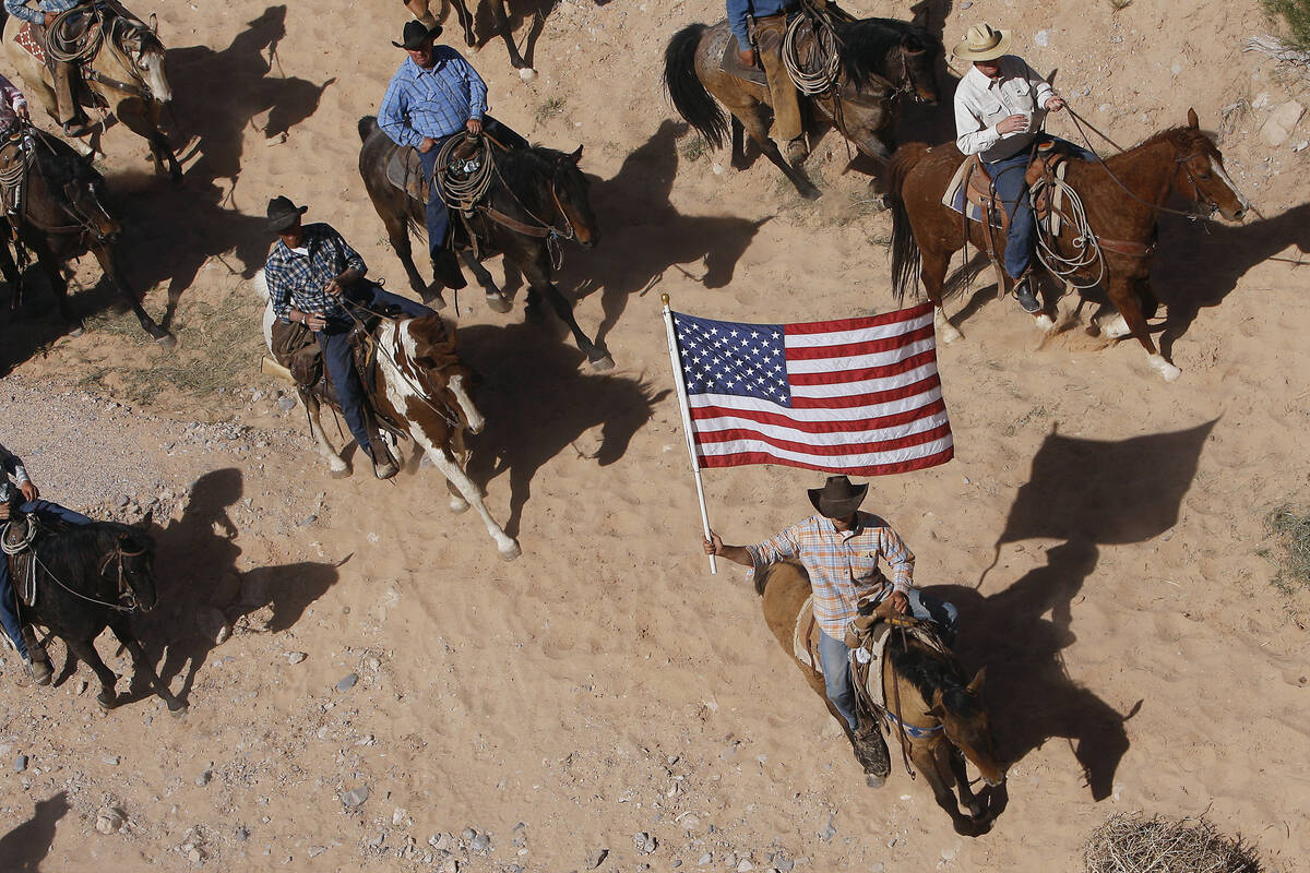 In this April 12, 2014, file photo, the Bundy family and their supporters fly the American flag ...
