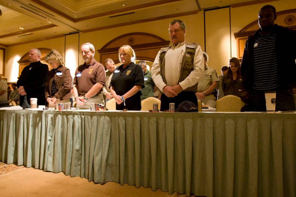 Oath Keepers members and guests bow their heads during the invocation at the Oath Keepers inaug ...