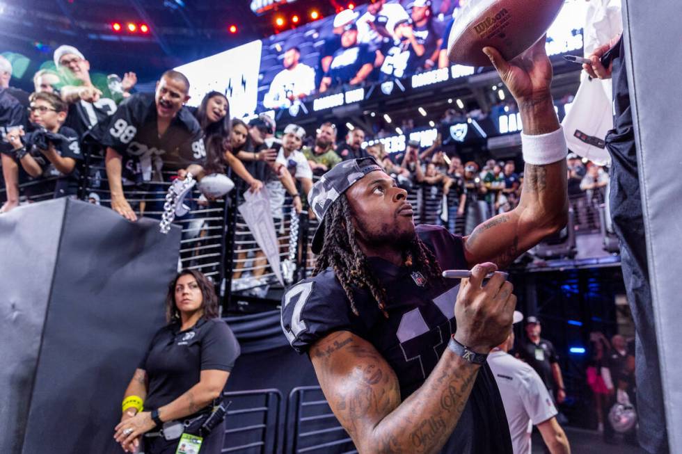 Raiders wide receiver Davante Adams (17) hands back an autographed ball to a fan after defeatin ...