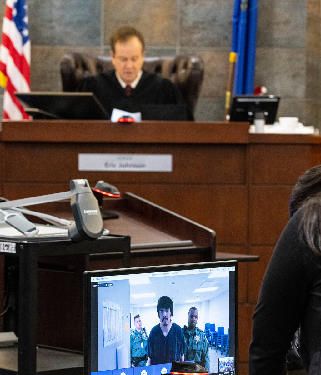 Hector Orellana, appearing in court via videoconference, listens as District Judge Eric Johnson ...