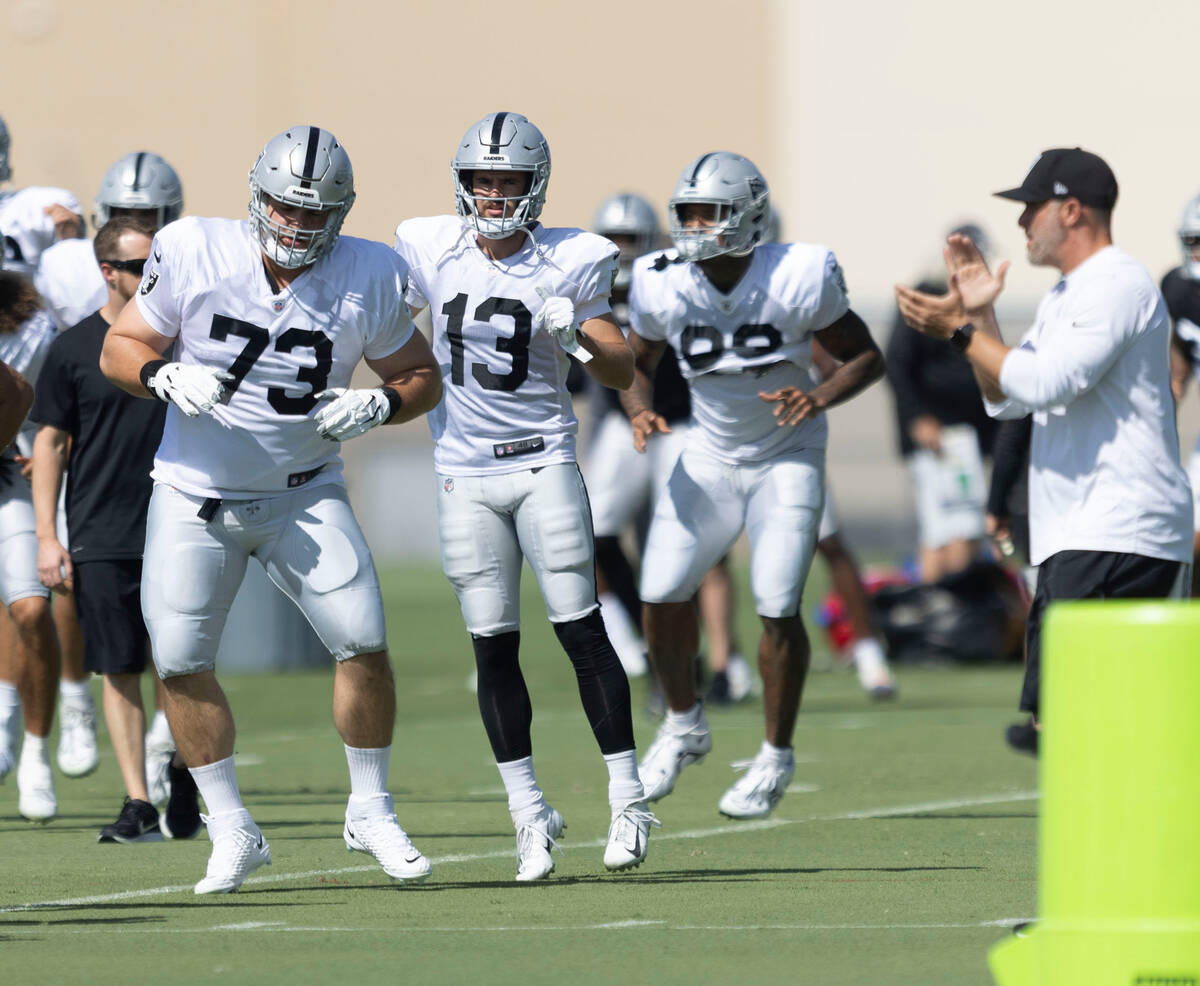 Raiders offensive lineman Vitaliy Gurman (73) and wide receiver Hunter Renfrow (13) warm up dur ...