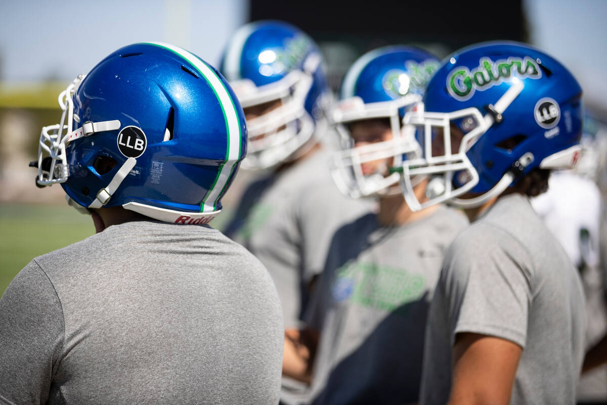 Players wear helmets with a decal in honor of late strength and conditioning coach Loymon Juan ...