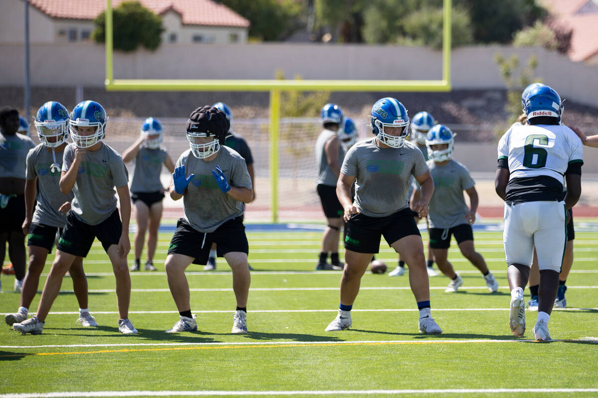 Players participate during a team football practice at Green Valley High School in Henderson, T ...