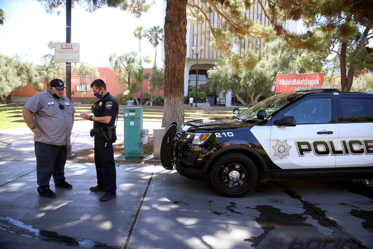 University police officer Ryan Willman, right, speaks to a campus worker who flagged him down a ...