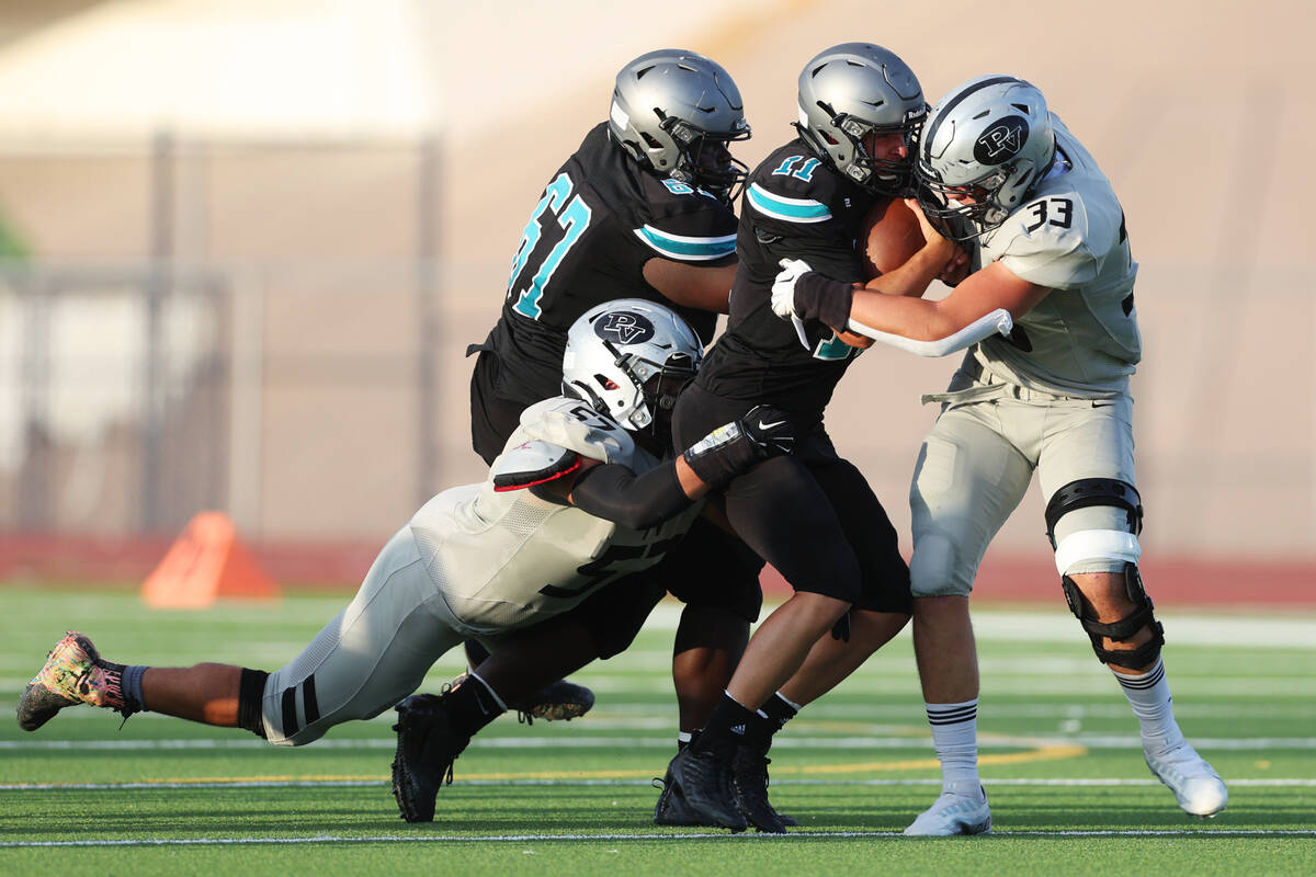 Silverado's Brandon Tunell (11) is tackled by Palo Verde's Sam Builes (33) and Jacob Chapman (5 ...