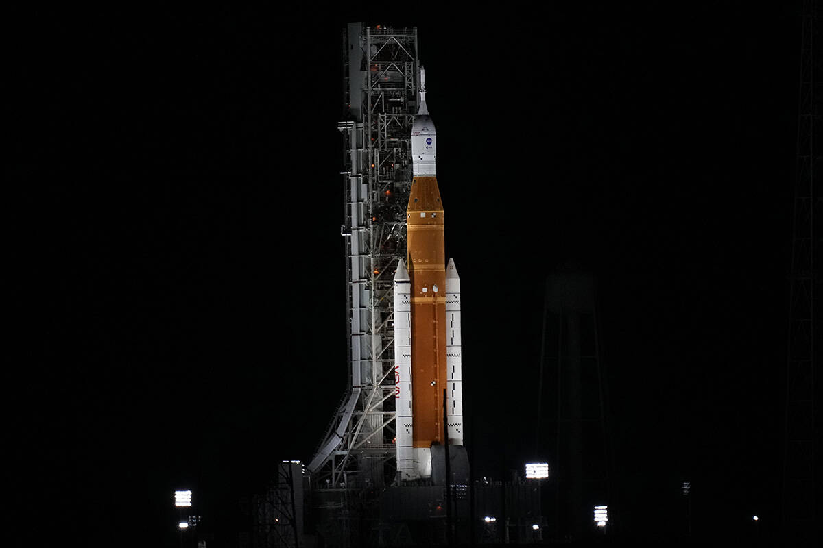 NASA's new moon rocket is illuminated by xenon lights as she sits on Launch Pad 39-B hours ahea ...
