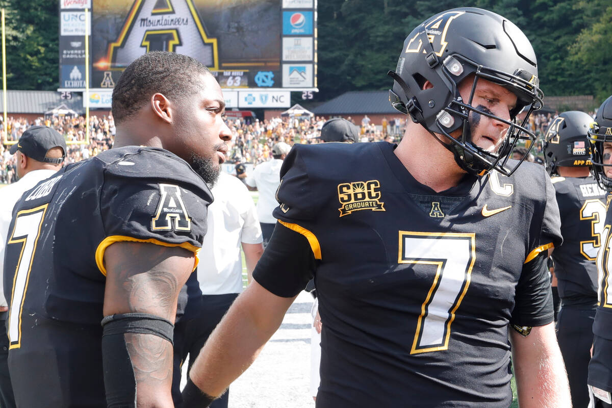 A dejected Appalachian State quarterback Chase Brice (right) is comforted by linebacker Trey Co ...