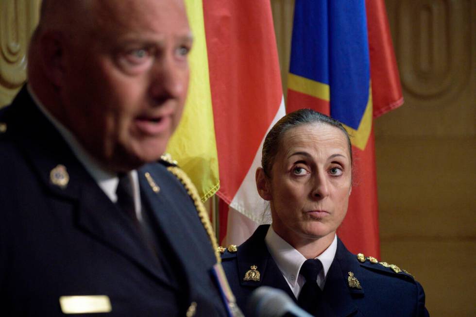 Assistant Commissioner Rhonda Blackmore, right, looks on while Regina Police Chief Evan Bray, l ...