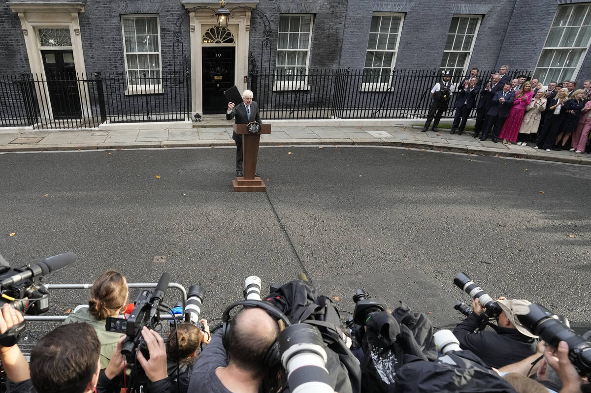 Outgoing British Prime Minister Boris Johnson gestures as he finishes his speech outside Downin ...