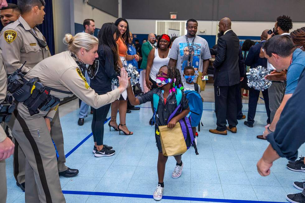 Metro officers join others in a red carpet welcome for students on their first day of school at ...