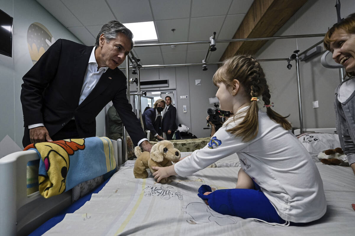 US Secretary of State Antony Blinken gives a gift to Marina, 6, from Kherson region, during a v ...