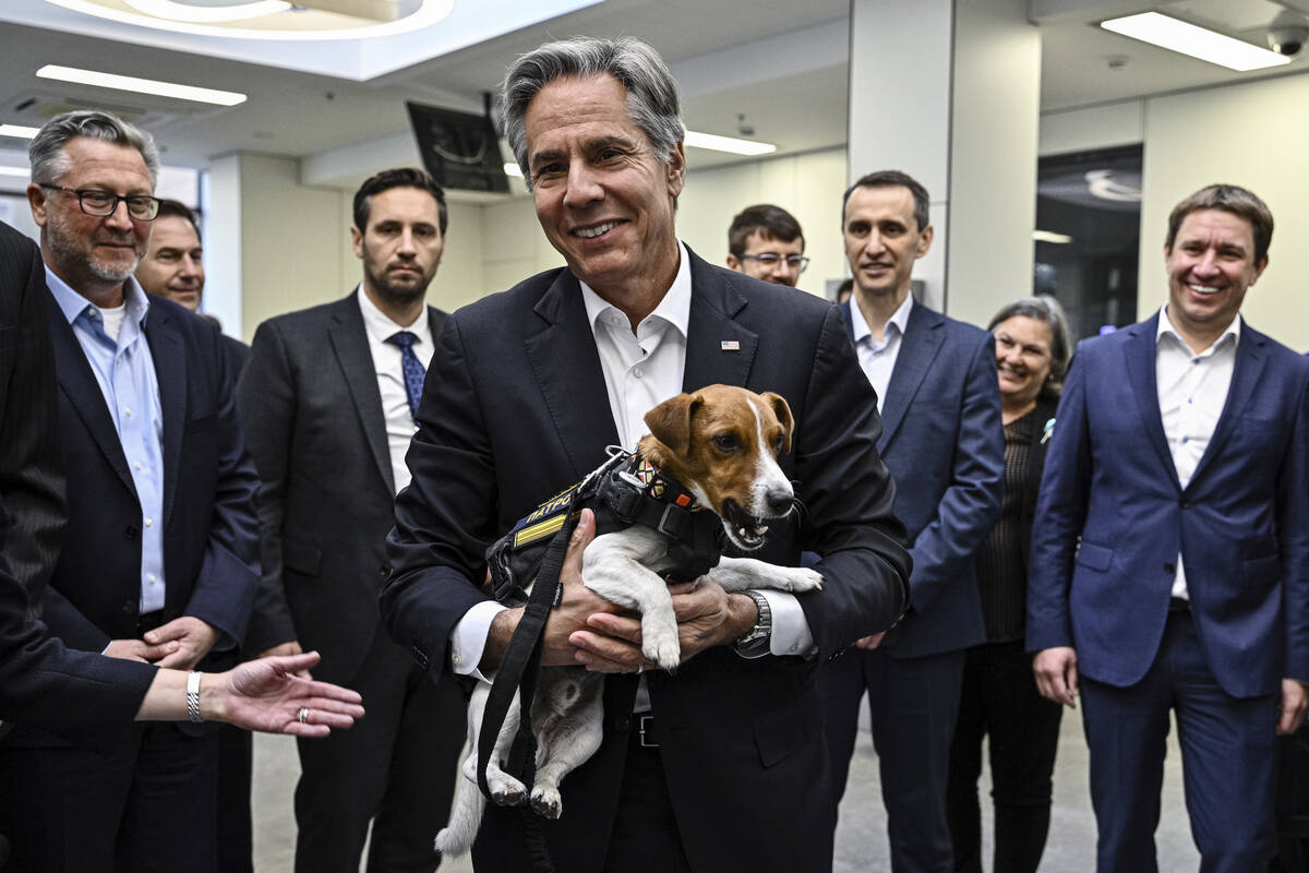 US Secretary of State Antony Blinken, center, holds a landmine sniffer dog, Jack Russell Terri ...