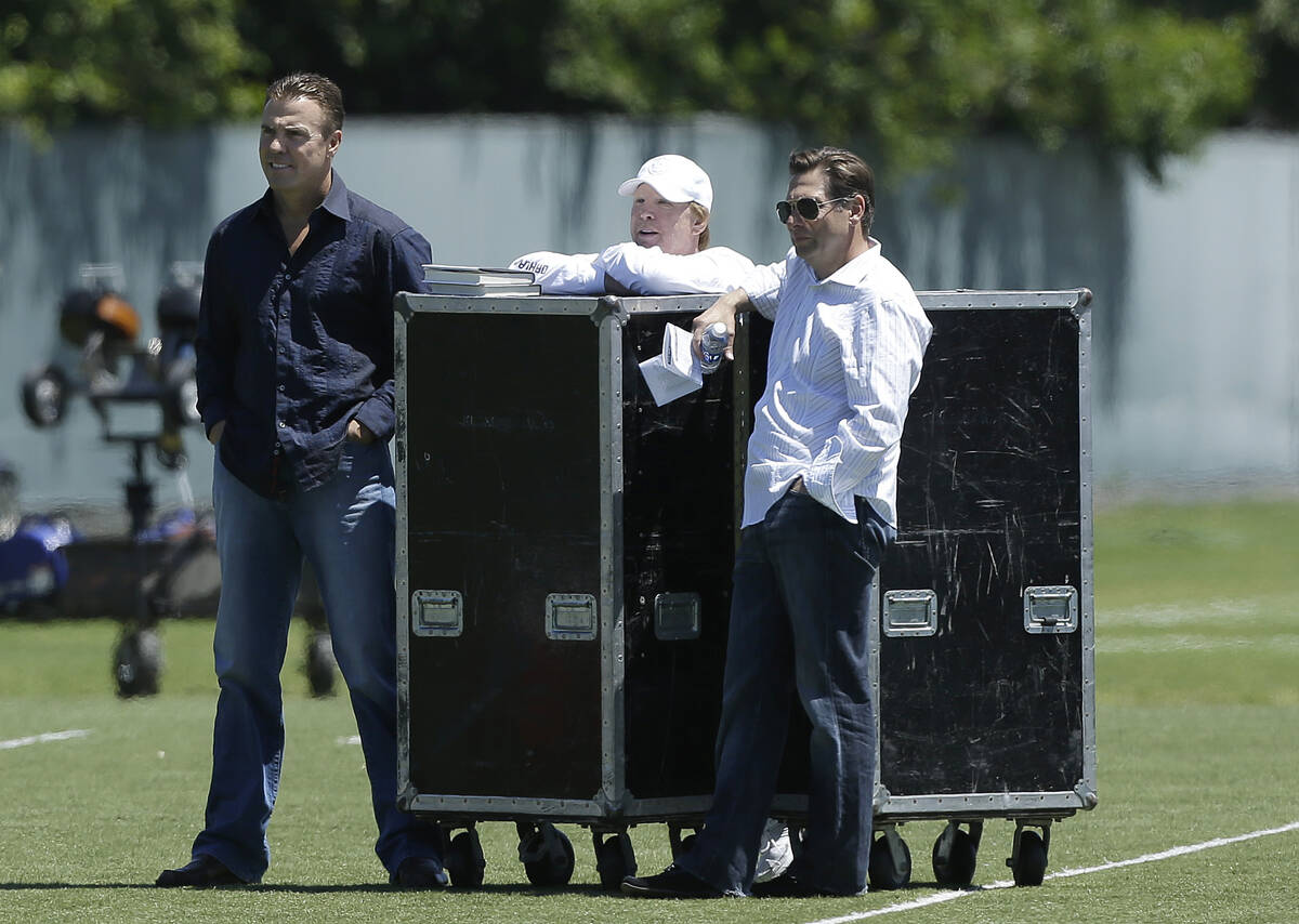 Oakland Raiders owner Mark Davis, center, watches practice with former linebacker Bill Romanows ...