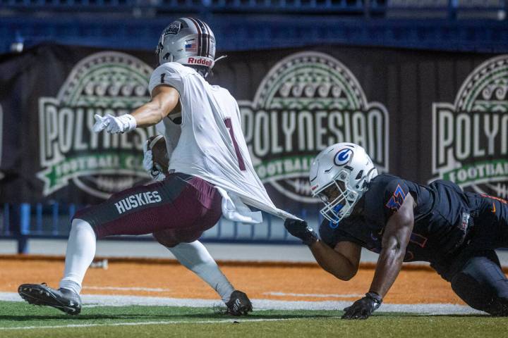 Hamilton kickoff receiver Jason De La Torre is pulled down by his jersey by Bishop Gorman lineb ...