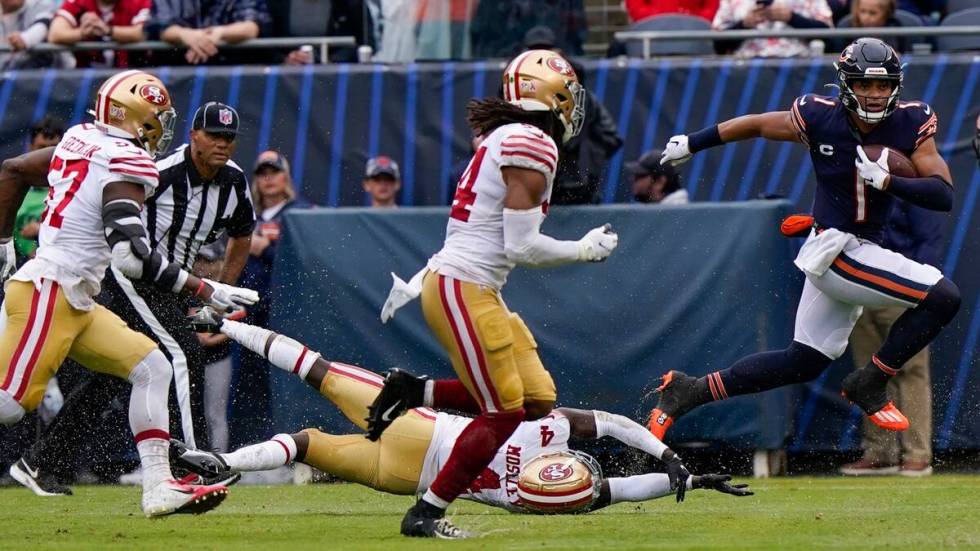 Chicago Bears' Justin Fields runs during the first half of an NFL football game against the San ...