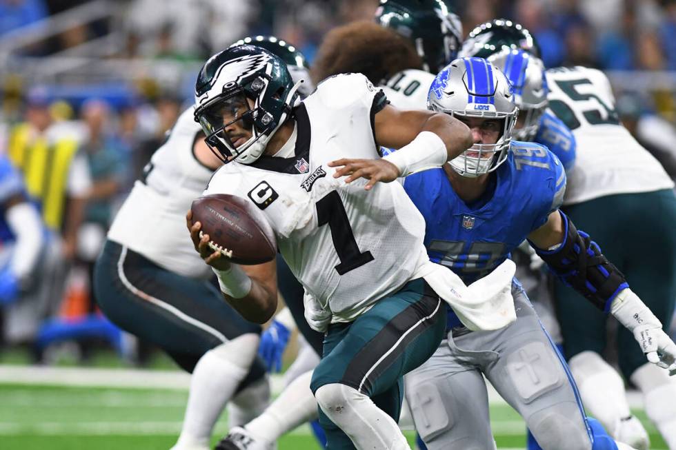 Philadelphia Eagles quarterback Jalen Hurts (1) escapes Detroit Lions defensive end Aidan Hutch ...