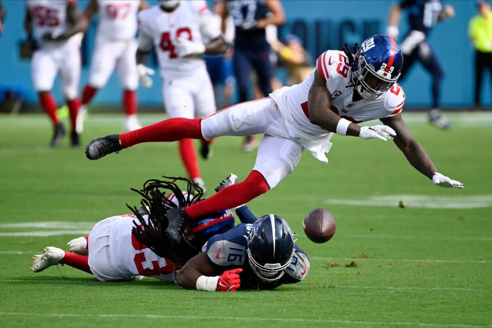 New York Giants cornerback Aaron Robinson (33) and safety Xavier McKinney (29) break up a pass ...