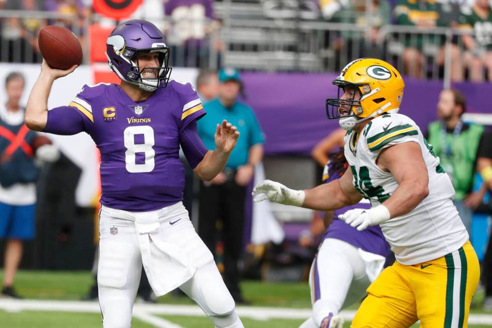 Minnesota Vikings quarterback Kirk Cousins (8) throws a pass as he is pressured by Green Bay Pa ...