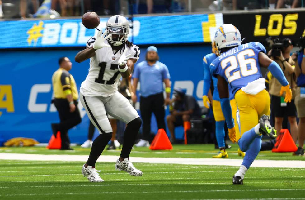 Raiders wide receiver Davante Adams (17) reaches out to make the reception under pressure from ...