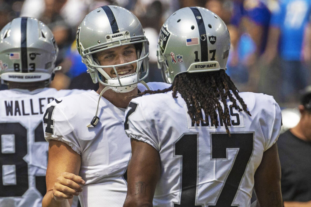 Raiders quarterback Derek Carr (4) and Raiders wide receiver Davante Adams (17) meet on the sid ...