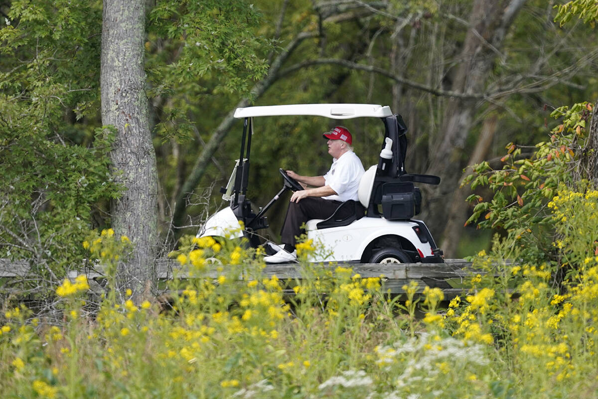 Former President Donald Trump rides around his golf course at Trump National Golf Club in Sterl ...