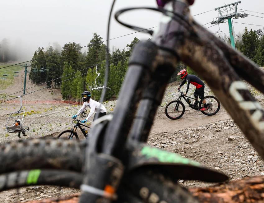 Bicyclists ride down a path at the downhill mountain bike park at Lee Canyon resort in Las Vega ...