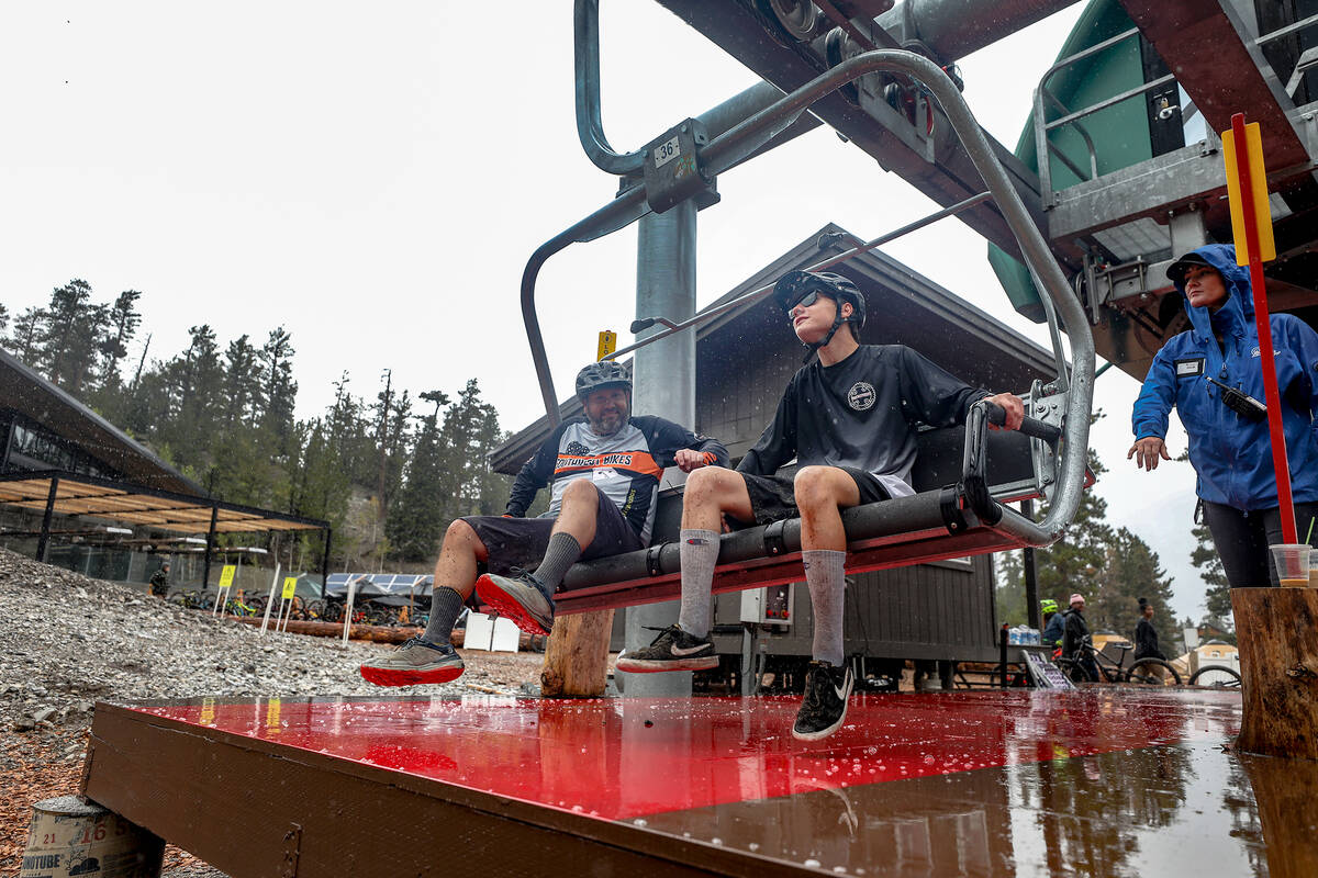 Spencer Dunsmoor, left, and his son Ethan Dunsmoor, right, hop on the ski lift at the downhill ...