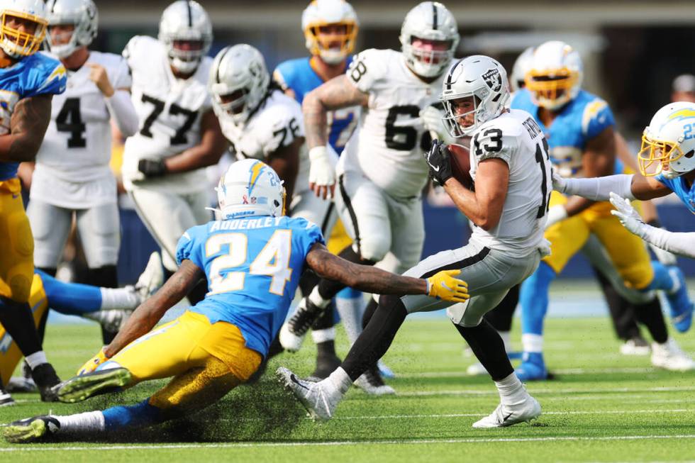 Raiders wide receiver Hunter Renfrow (13) makes a catch under pressure from Los Angeles Charger ...