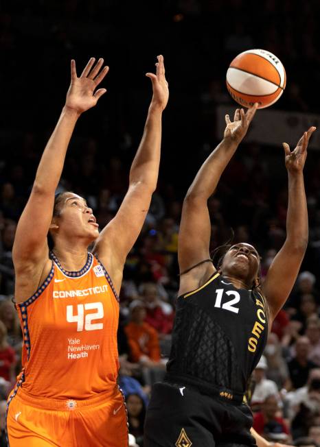 Las Vegas Aces guard Chelsea Gray (12) shoots against Connecticut Sun center Brionna Jones (42) ...