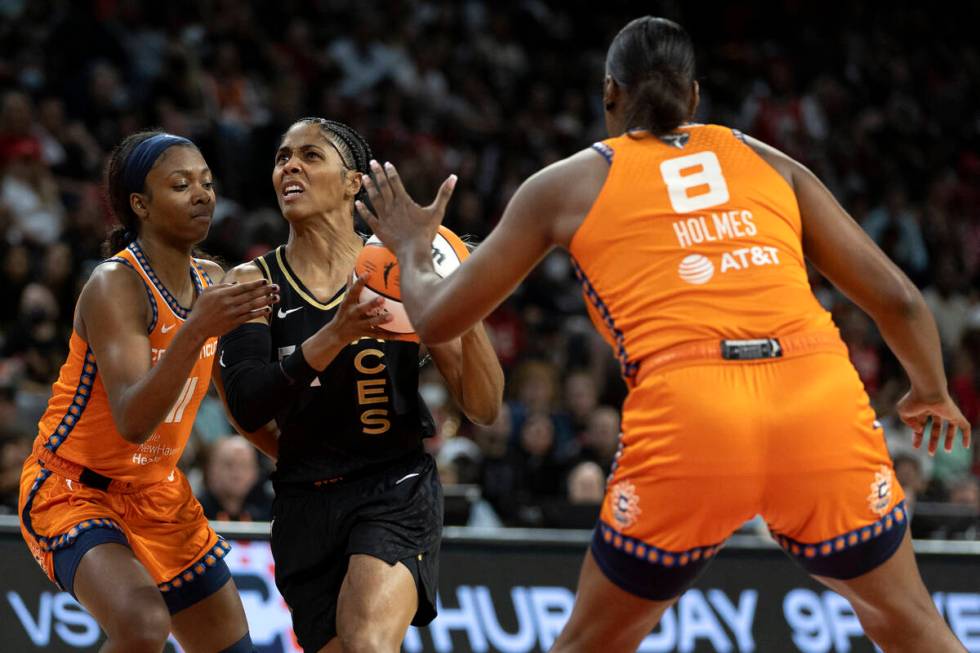 Las Vegas Aces guard Sydney Colson (51) drives toward the hoop while Connecticut Sun guard Nia ...