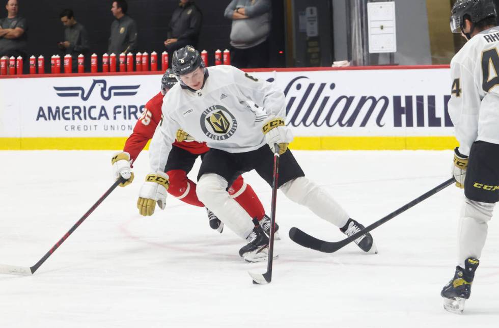 Golden Knights defenseman Kaedan Korczak (6) skates with the puck under pressure from forward C ...