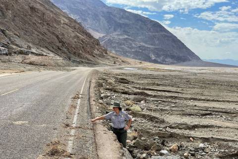 Death Valley National Park spokeswoman Abby Wines stands in an eroded shoulder on the side of B ...