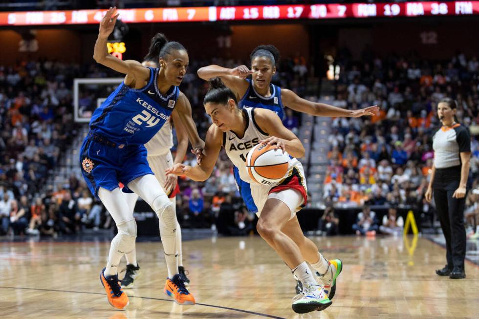 Las Vegas Aces guard Kelsey Plum (10) dribbles around Connecticut Sun forward DeWanna Bonner (2 ...