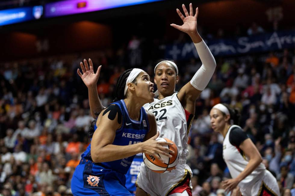 Connecticut Sun center Brionna Jones (42) drives around Las Vegas Aces forward A'ja Wilson (22) ...