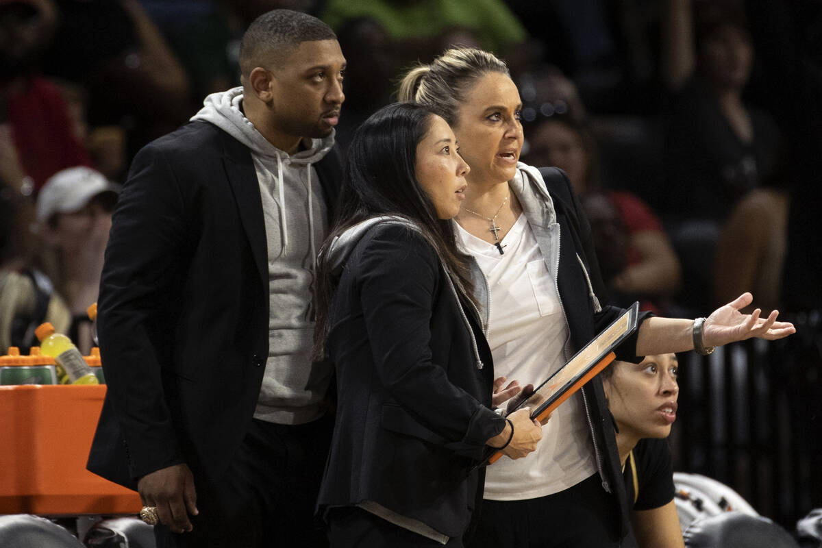 Las Vegas Aces head coach Becky Hammon, right, communicates with assistant coaches Tyler Marsh, ...