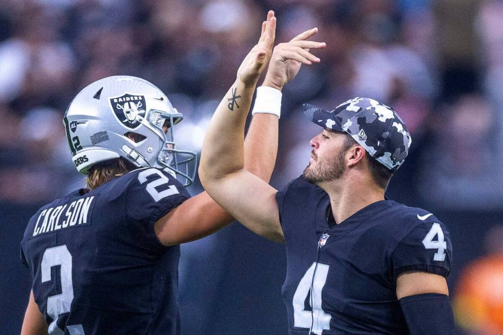 Raiders quarterback Derek Carr (4) congratulates place kicker Daniel Carlson (2) on another sco ...