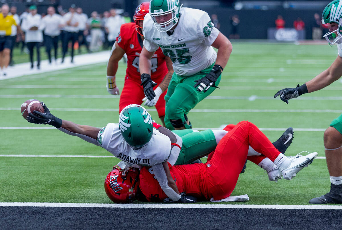 North Texas Mean Green running back Oscar Adaway III (27) leans back to score over a tackle att ...