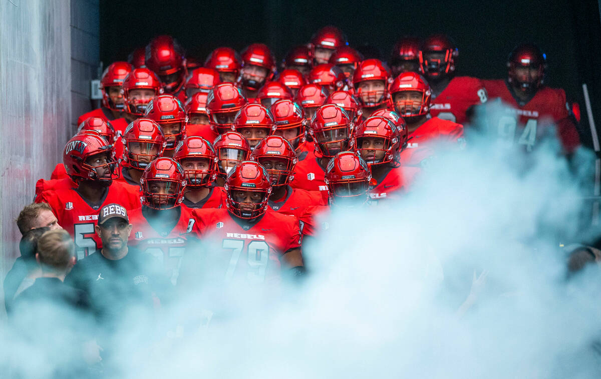 UNLV Rebels head coach Marcus Arroyo and players await to be introduced behind smoke before fac ...