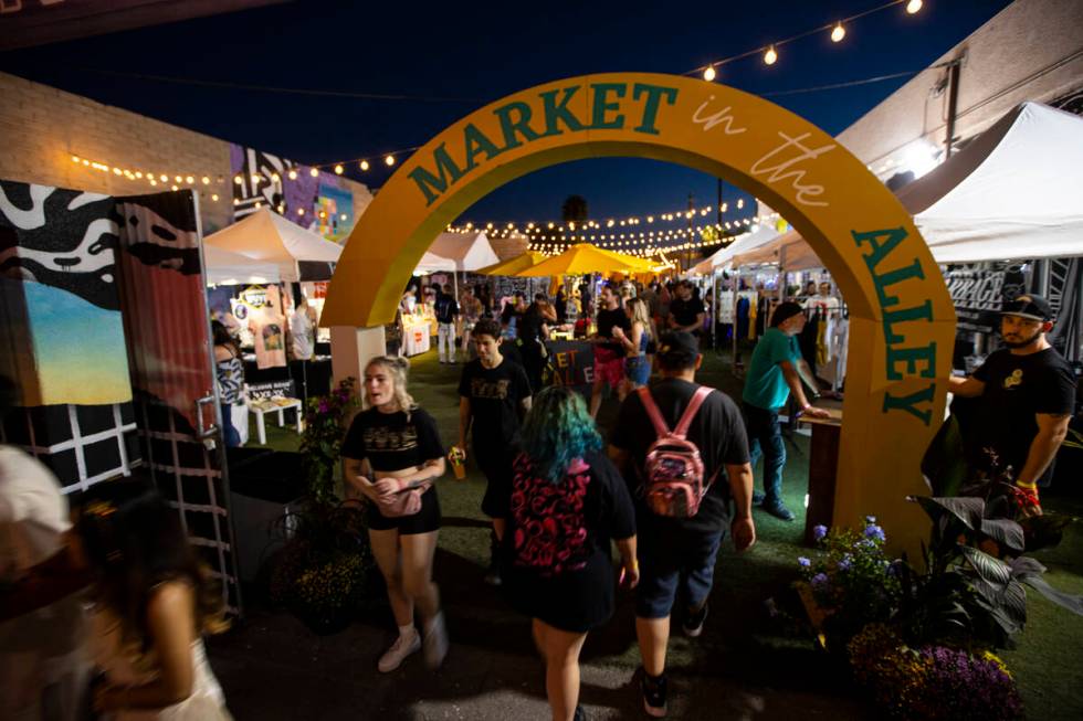 Attendees walk through the Market in the Alley area during the Life is Beautiful festival on Sa ...