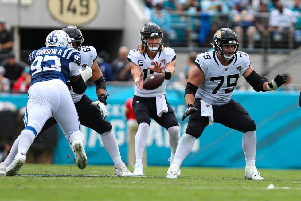 Jacksonville Jaguars quarterback Trevor Lawrence (16) takes the snap form center Luke Fortner ( ...