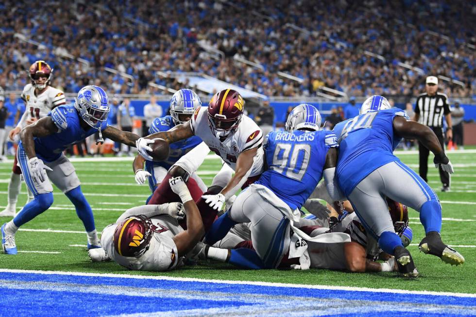 Washington Commanders running back Antonio Gibson (24) dives to the end zone for a touchdown du ...