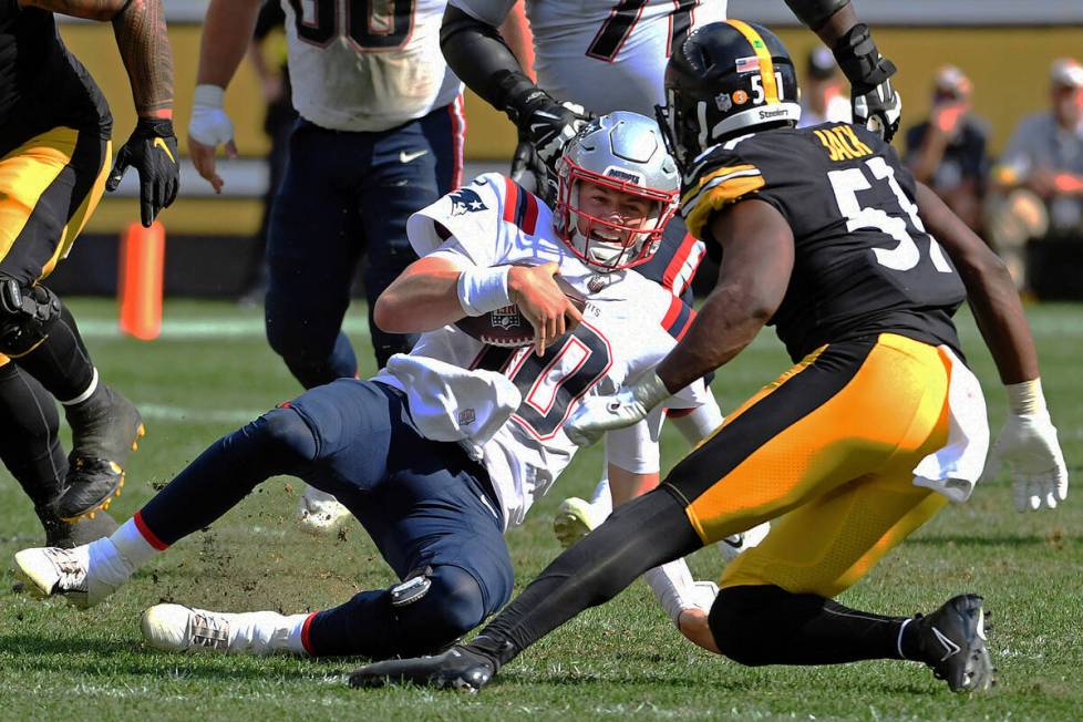 New England Patriots quarterback Mac Jones (10) begins his slide after a short gain with Pittsb ...