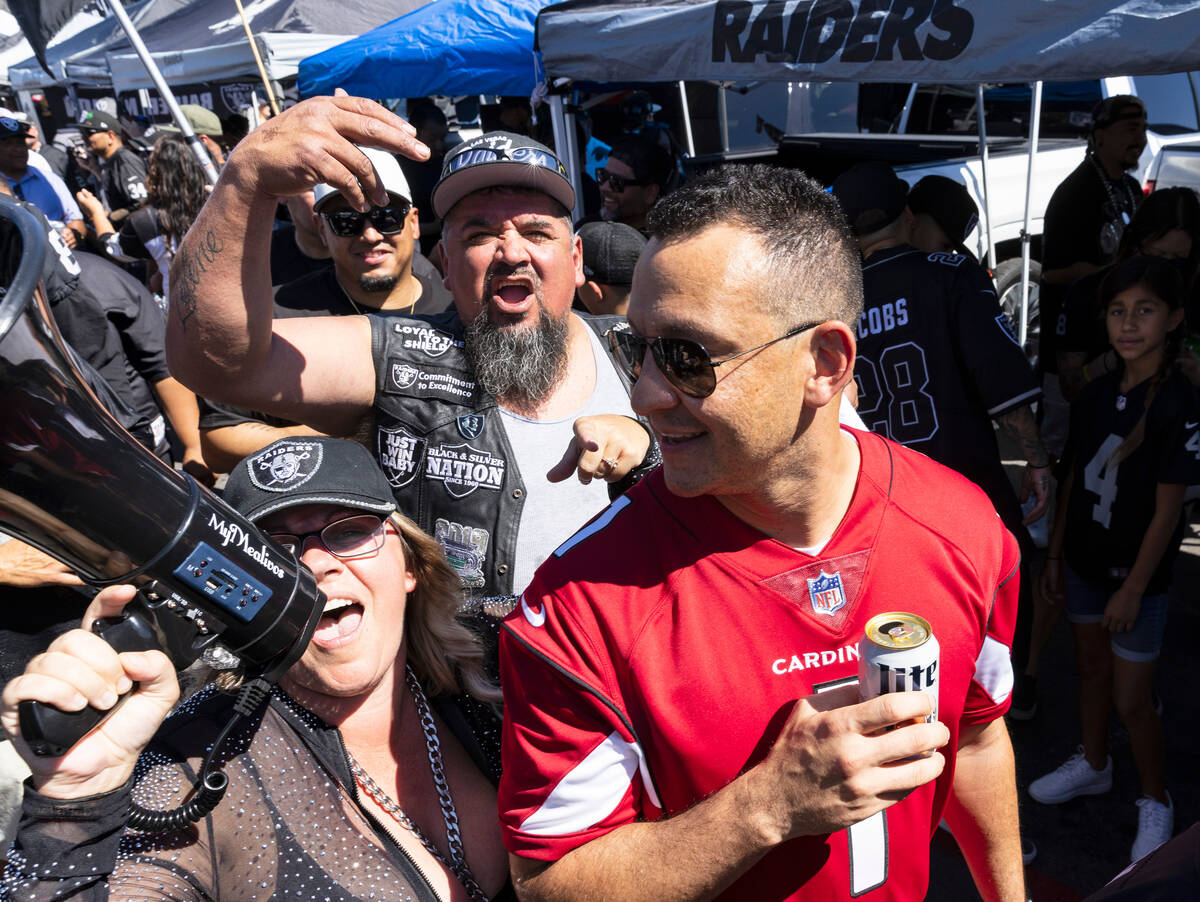 Arizona Cardinals fan Anthony Cien is surrounded by Raiders fans at a tailgate area out side of ...