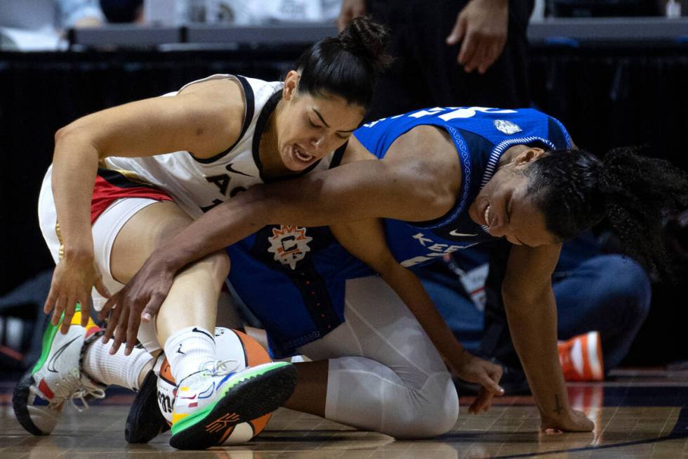 Las Vegas Aces guard Kelsey Plum (10) and Connecticut Sun forward Alyssa Thomas (25) fight for ...