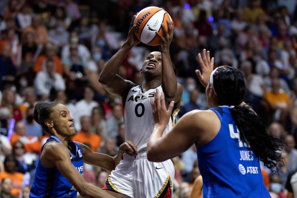 Las Vegas Aces guard Jackie Young (0) shoots against Connecticut Sun forward DeWanna Bonner (24 ...