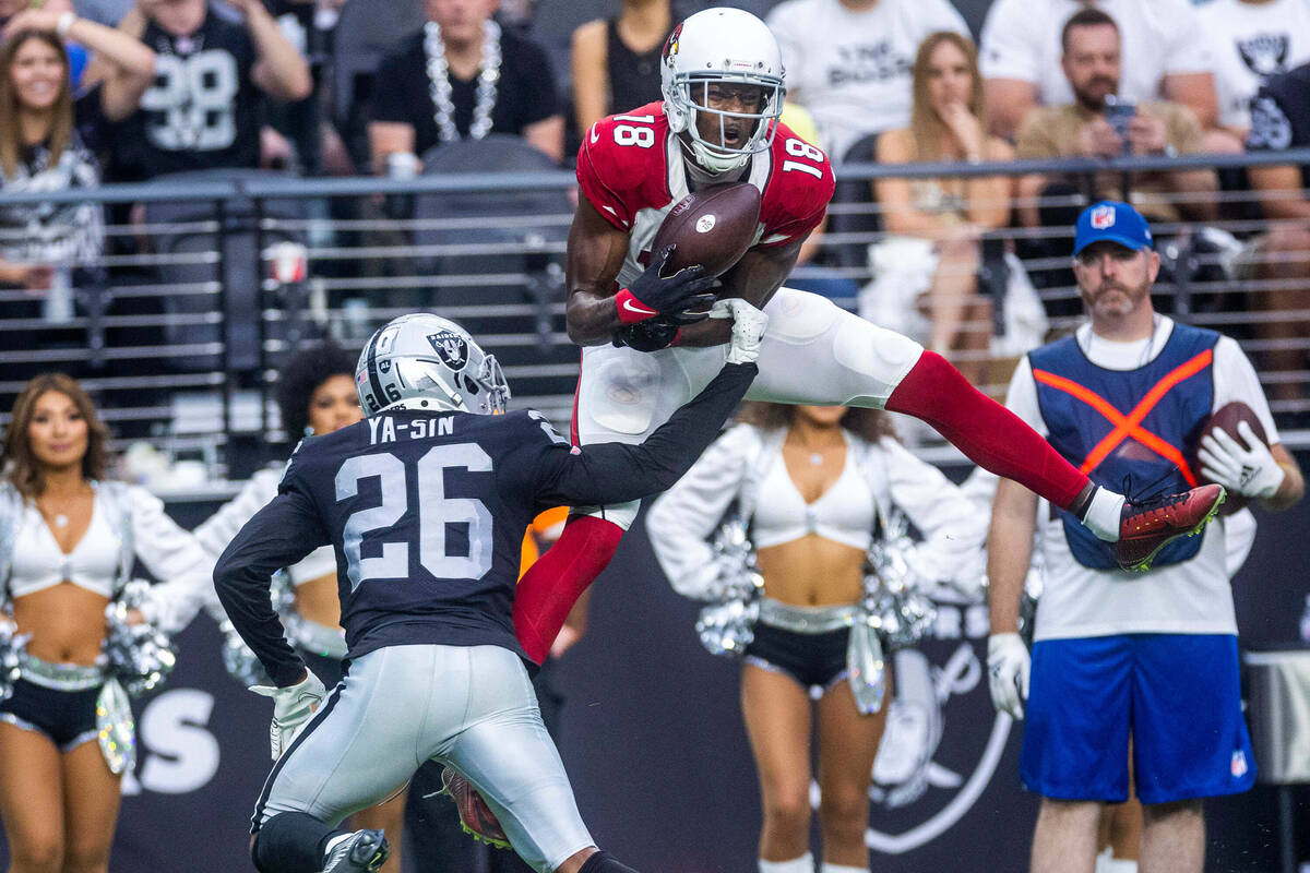 Arizona Cardinals wide receiver A.J. Green (18) attempts to secure a long pass as Raiders corne ...