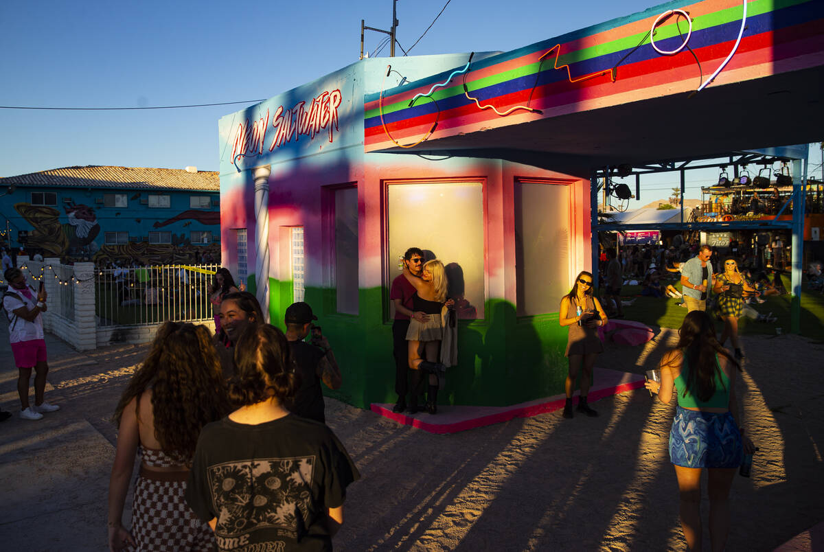 Attendees hang out by an art installation created out of a 1931 gas station during the Life is ...