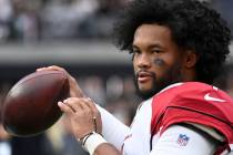Arizona Cardinals quarterback Kyler Murray warms up on the sideline during the first half of an ...
