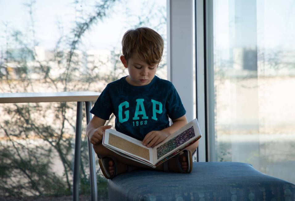 Parker Pinault, 7, reads at the grand opening of the West Henderson Library branch on Tuesday, ...